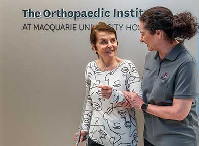 A nurse escorting a patient outside the Orthopaedic Institute building